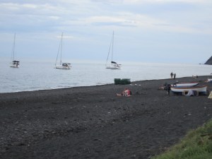 black beach with sailboats